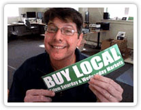 John from Websticker holds a Buy Local sticker to demonstrate importance of simple design